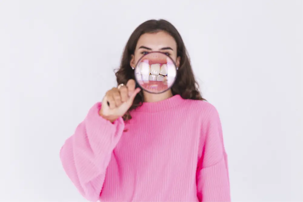 mujer con lupa en los dientes