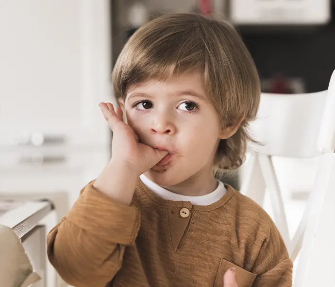 niño chapándose el dedo
