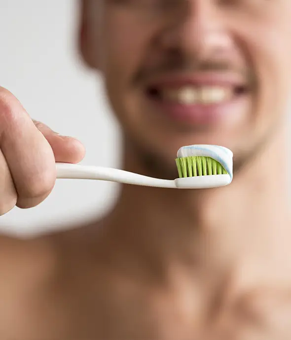 hombre de fondo con cepillo dental y pasta en la mano
